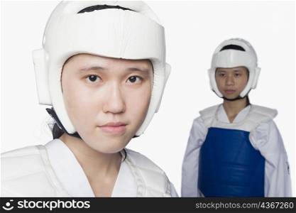 Portrait of a young woman wearing a sports helmet with another young woman standing in the background