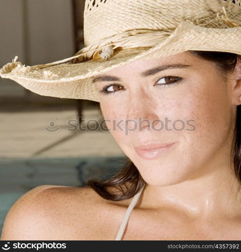 Portrait of a young woman wearing a straw hat