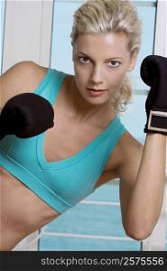 Portrait of a young woman wearing boxing gloves