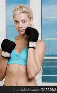 Portrait of a young woman wearing boxing gloves