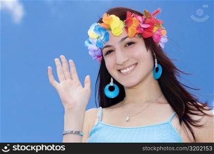 Portrait of a young woman wearing flowers and waving her hand