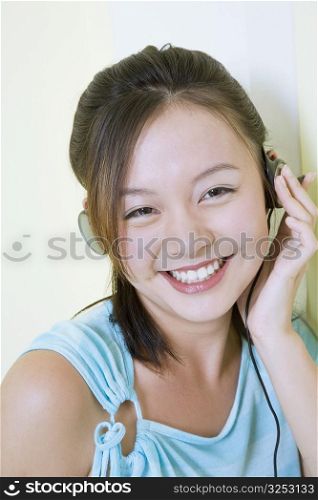 Portrait of a young woman wearing headphones and listening to music