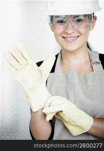 Portrait of a young woman wearing protective gloves and smiling
