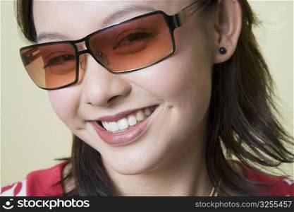 Portrait of a young woman wearing sunglasses and smiling