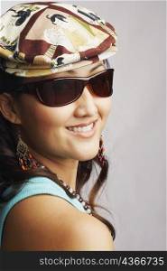 Portrait of a young woman wearing sunglasses and smiling