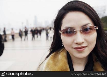 Portrait of a young woman wearing sunglasses smiling