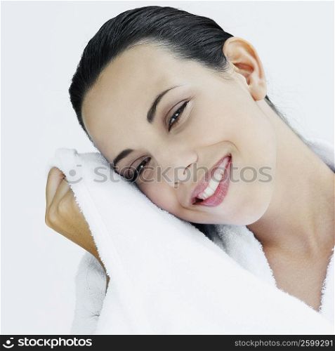 Portrait of a young woman wiping her face with a towel