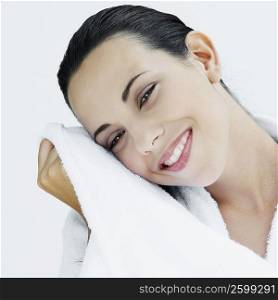 Portrait of a young woman wiping her face with a towel