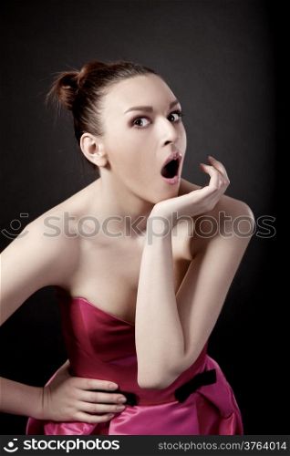 Portrait of a young woman with a astonish expression, isolated over black background