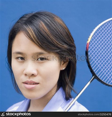 Portrait of a young woman with a badminton racket