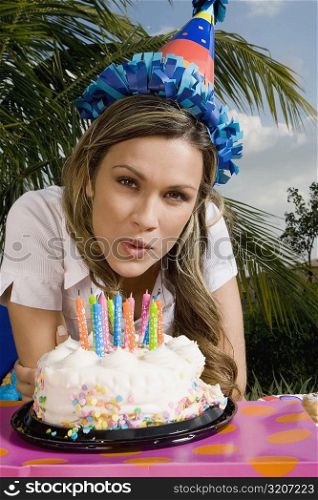 Portrait of a young woman with a cake in front of her