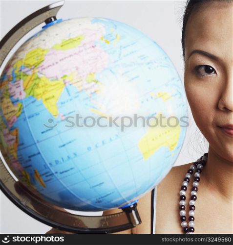 Portrait of a young woman with a globe