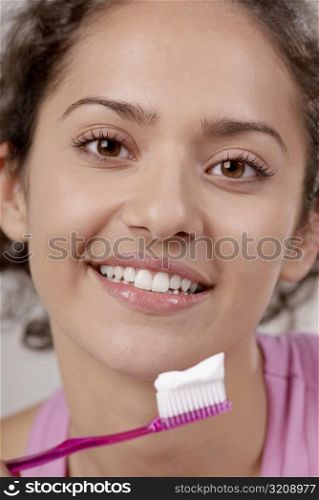 Portrait of a young woman with a toothbrush in front of her mouth
