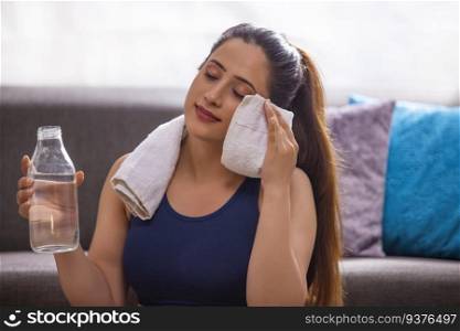 Portrait of a young woman with a water bottle after workout