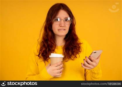 Portrait of a young woman with a worried expression on her face while using a mobile phone.
