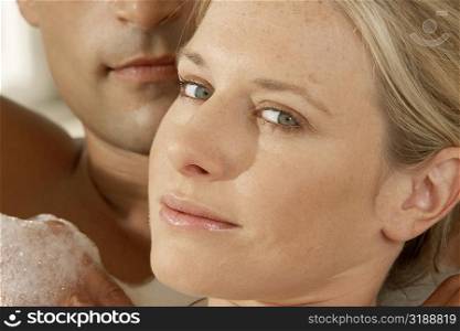 Portrait of a young woman with a young man in a bubble bath