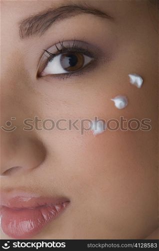 Portrait of a young woman with cream on her cheek