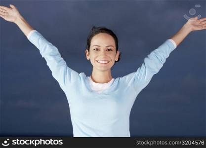 Portrait of a young woman with her arms outstretched