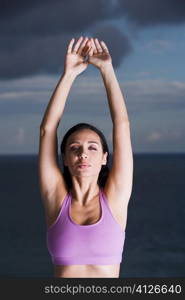 Portrait of a young woman with her arms raised