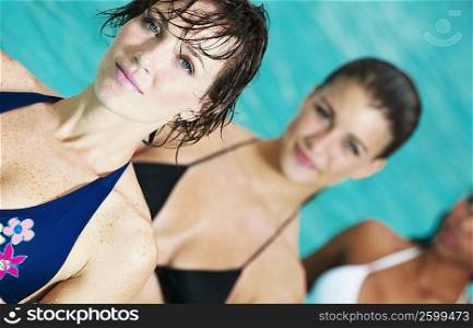 Portrait of a young woman with her friends in a swimming pool