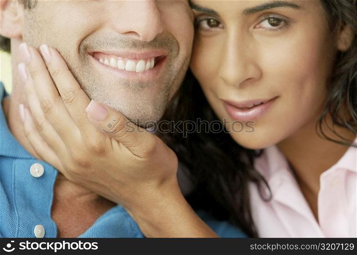 Portrait of a young woman with her hand on a young man&acute;s chin