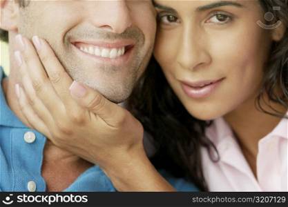 Portrait of a young woman with her hand on a young man&acute;s chin