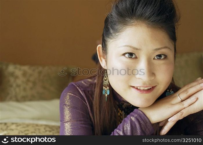 Portrait of a young woman with her hand on her chin smiling