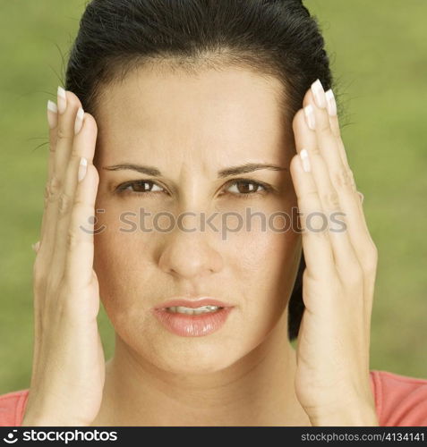 Portrait of a young woman with her hands on her head