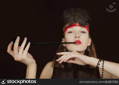 Portrait of a young woman with opium pipe on a black background. retro style