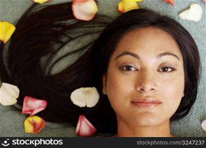 Portrait of a young woman with petals around her
