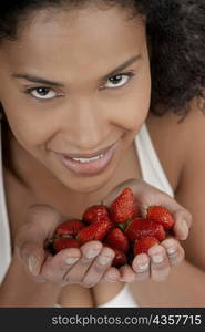 Portrait of a young woman with strawberries in her hands