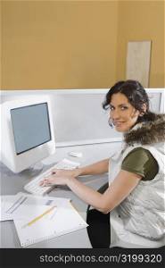 Portrait of a young woman working on a computer and smiling