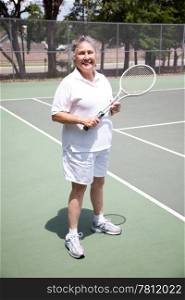 Portrait of active senior woman on the tennis courts.