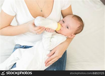 Portrait of adorable baby boy drinking milk from bottle