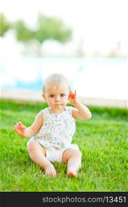 Portrait of adorable baby sitting on grass&#xA;