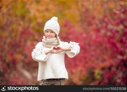 Portrait of adorable little girl outdoors at beautiful autumn day outdoors with amazing pink tree background. Adorable little girl at beautiful autumn day outdoors