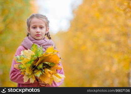 Portrait of adorable little girl outdoors at beautiful warm day with yellow leaves in fall. Portrait of adorable little girl outdoors at beautiful warm day with yellow leaf in fall