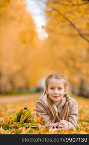 Portrait of adorable little girl outdoors at beautiful warm day with yellow leaves in fall. Portrait of adorable little girl outdoors at beautiful warm day with yellow leaf in fall