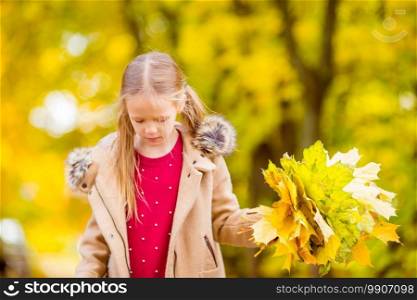 Portrait of adorable little girl with yellow leaves bouquet in fall at autumn park outdoors. Portrait of adorable little girl with yellow leaves bouquet in fall