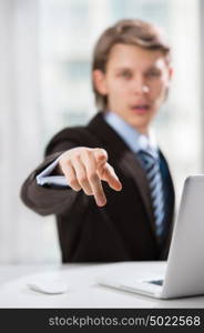 Portrait of adult business man pointing at you at his office