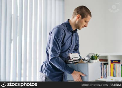 Portrait of adult caucasian man businessman wearing shirt holding a box personal items stuff leaving the office being fired from work due recession economic crisis downturn losing job company shutdown