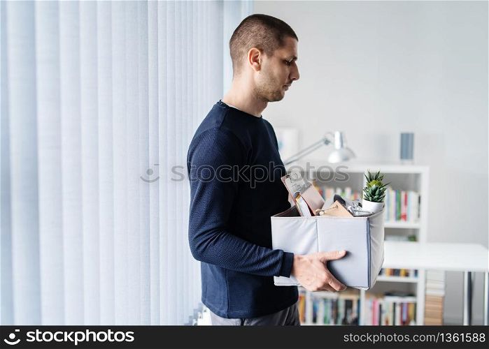Portrait of adult caucasian man businessman wearing shirt holding a box personal items stuff leaving the office being fired from work due recession economic crisis downturn losing job company shutdown