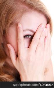 Portrait of afraid frightened woman peeking through her fingers isolated on white. Shy girl covering face with hands.