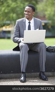 Portrait of African American Businessman working on a laptop outdoors