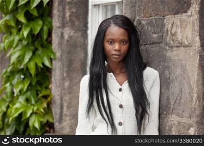 Portrait of African American female standing against stone wall