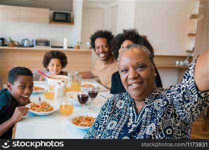 Portrait of african american multigenerational family taking a selfie together while having dinner at home. Family and lifestyle concept.