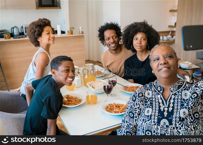 Portrait of african american multigenerational family taking a selfie together with mobile phone while having dinner at home. Family and lifestyle concept.