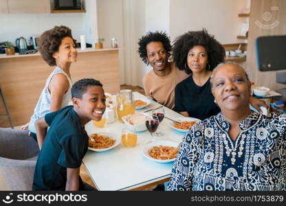 Portrait of african american multigenerational family taking a selfie together with mobile phone while having dinner at home. Family and lifestyle concept.