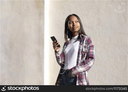 Portrait of African American young woman standing on the street while using a mobile phone