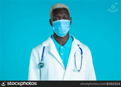 Portrait of african doctor in professional medical coat and mask. Doc man isolated on blue background. Portrait of african doctor in professional medical coat and mask. Doc man isolated on blue background.